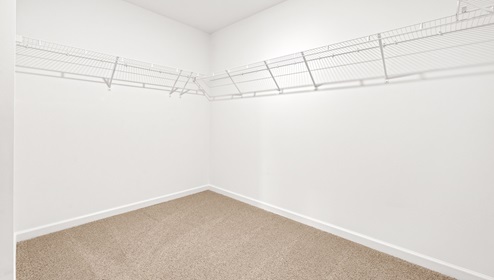 Primary closet with hanging shelves.