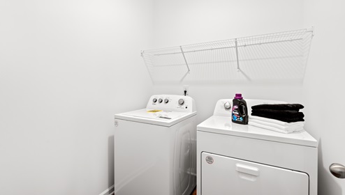 Laundry room with hanging shelves.