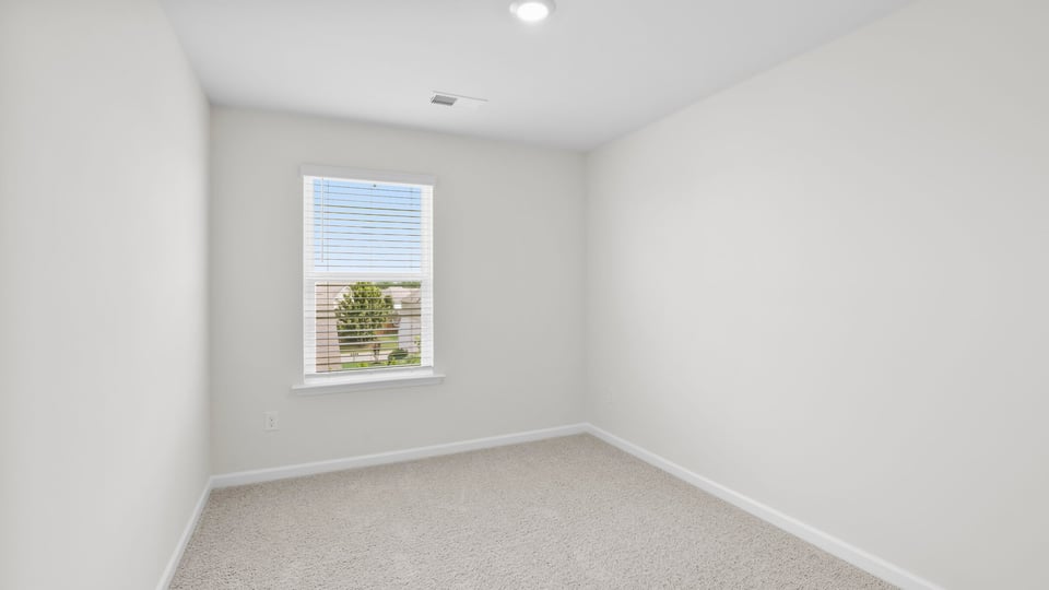 Bedroom with carpet and window.