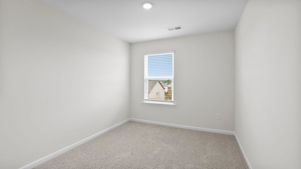 Bedroom with carpet and window.