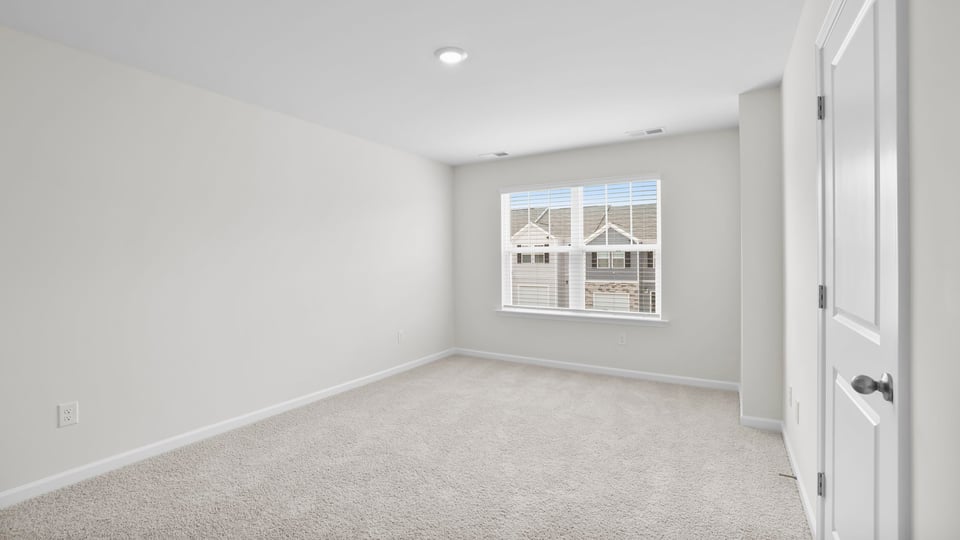 Bedroom with carpet and window.