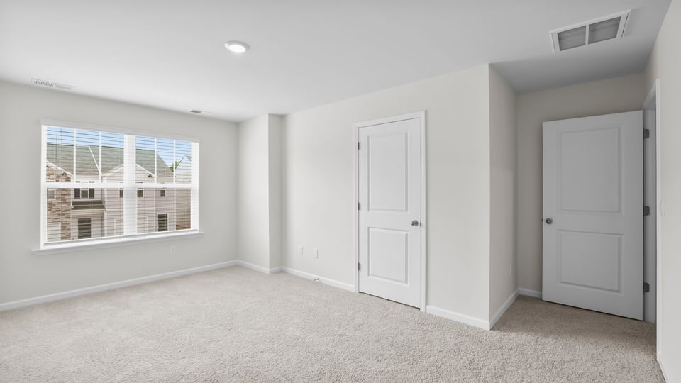 Bedroom with carpet and window.