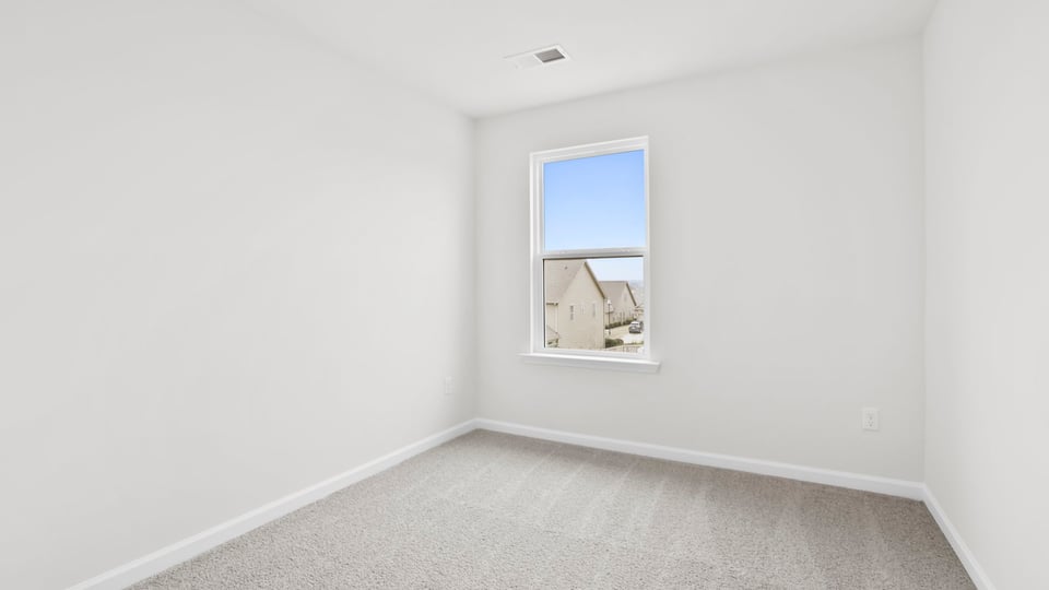 Bedroom with carpet and window.
