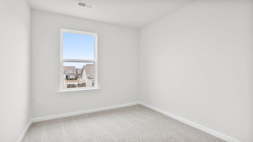 Bedroom with carpet and window.