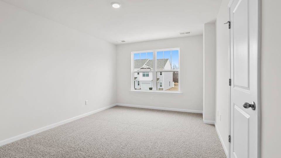 Bedroom with carpet and window.