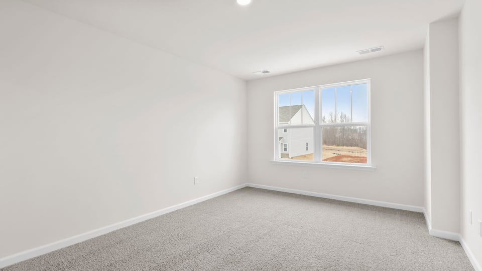 Bedroom with carpet and window.