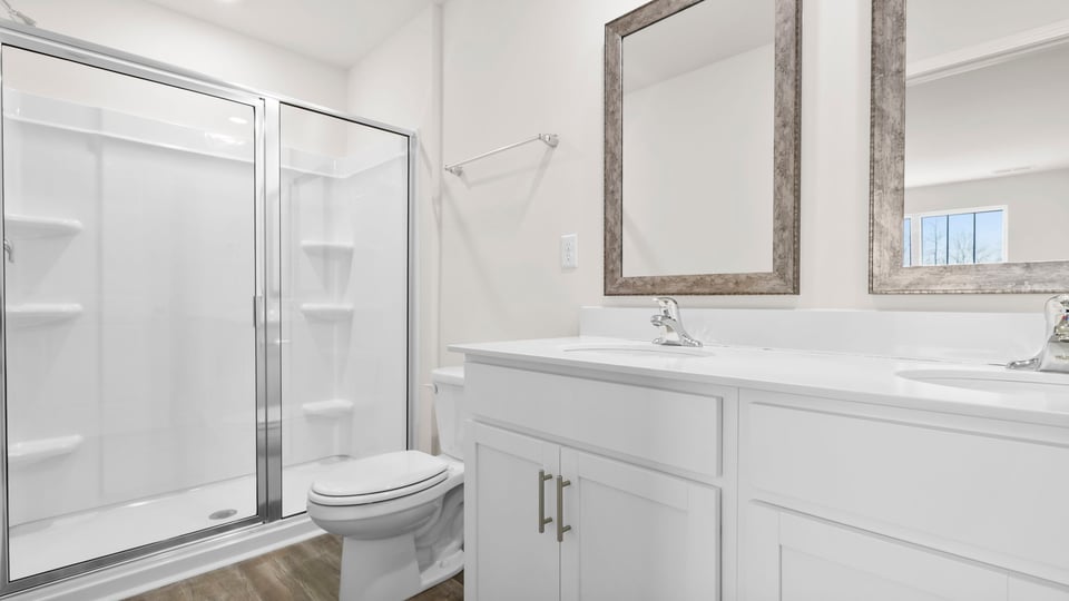 Bathroom with walk in shower and double sink vanity.