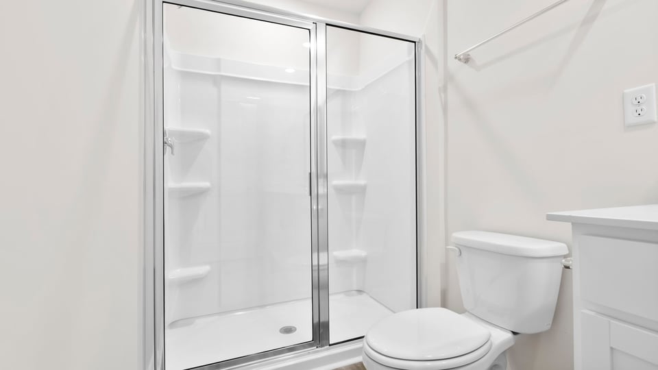 Bathroom with walk in shower and double sink vanity.