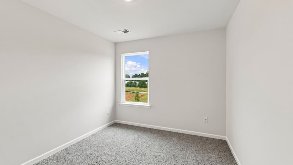 Bedroom with carpet and windows.
