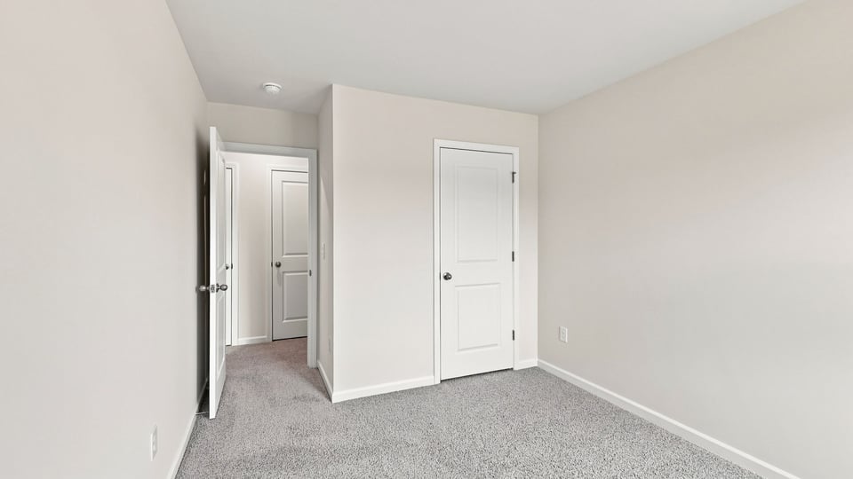Bedroom with carpet and windows.