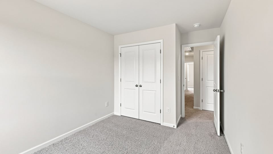 Bedroom with carpet and windows.