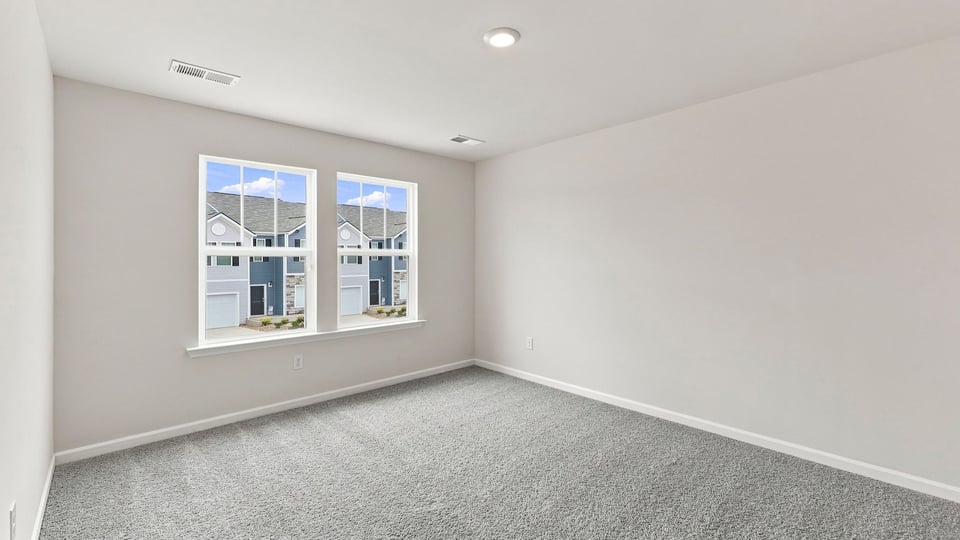 Bedroom with carpet and windows.