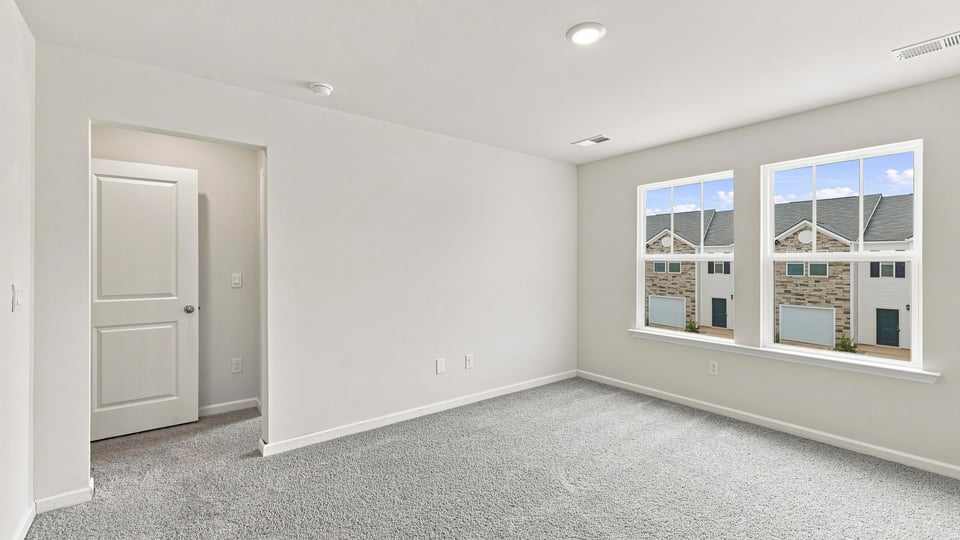 Bedroom with carpet and windows.