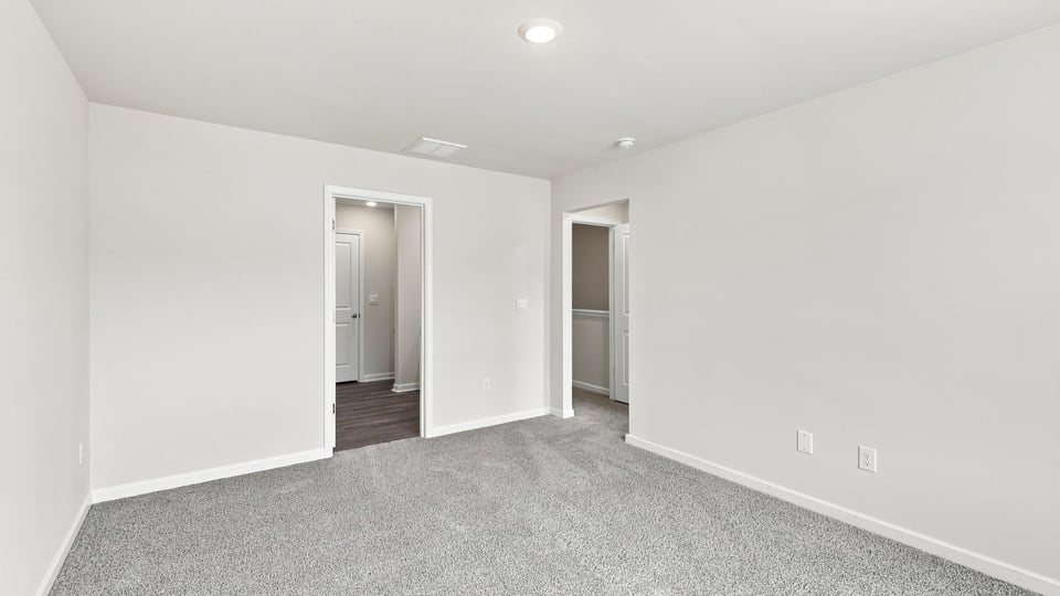 Bedroom with carpet and windows.