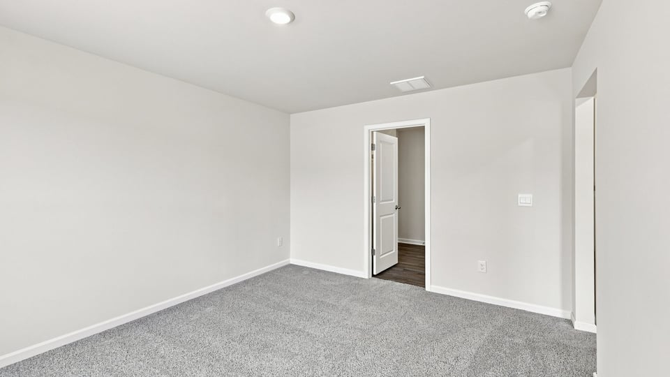 Bedroom with carpet and windows.