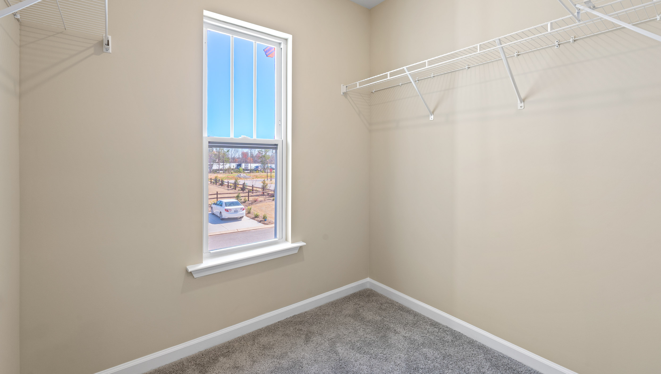 Walk in closet with shelves and window.