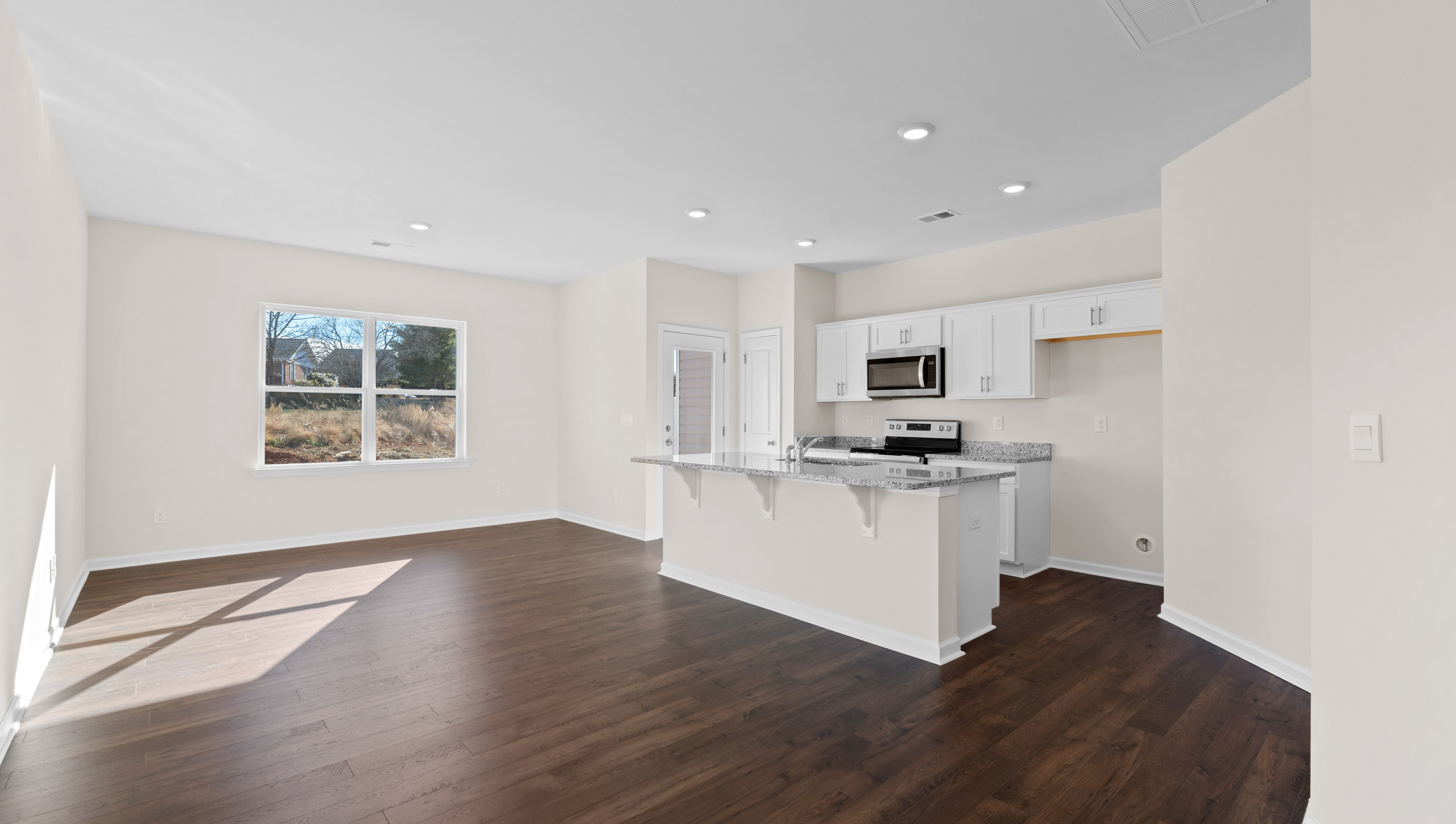 Family room and kitchen with windows.