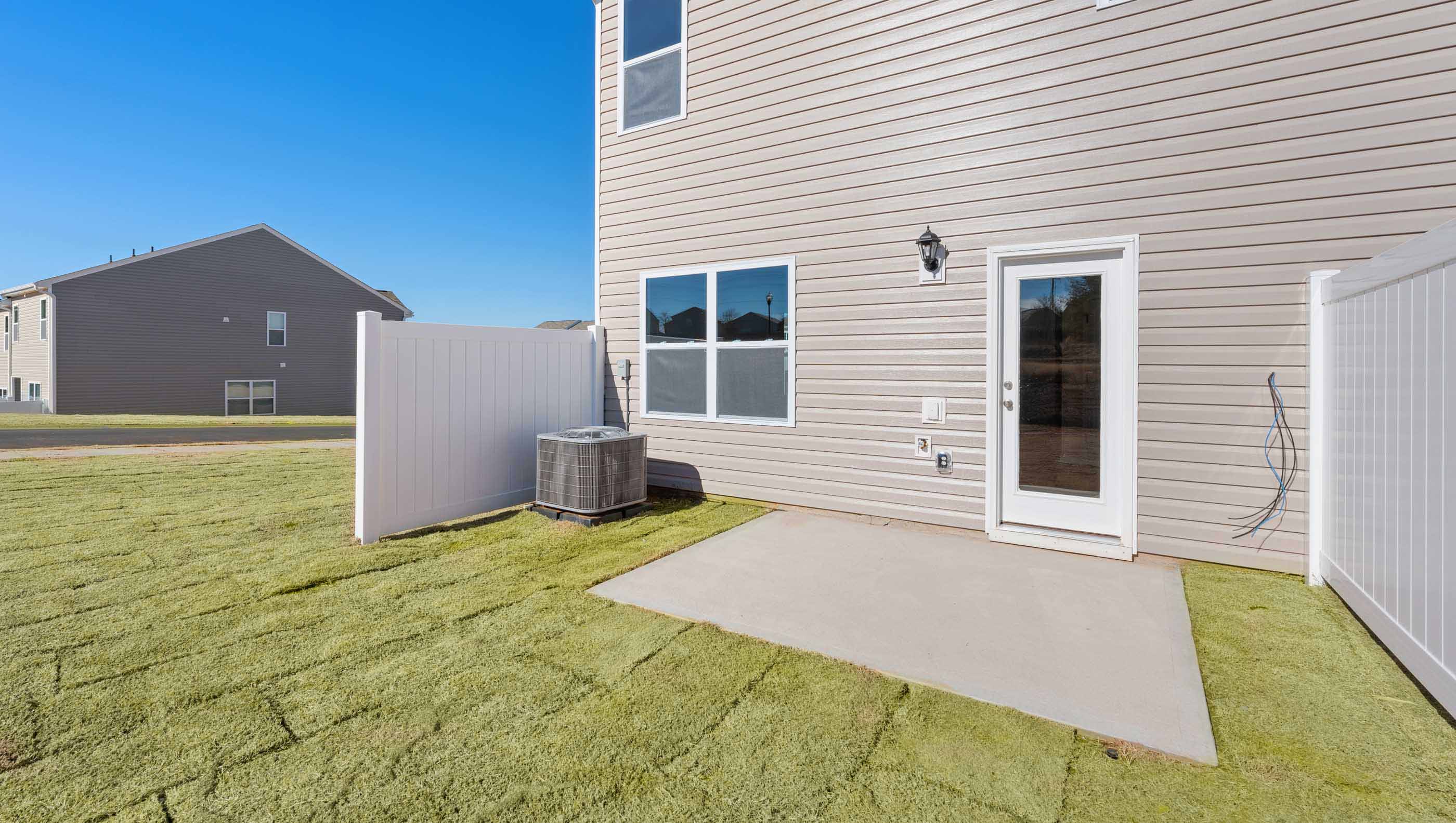 Back exterior of Newton with small patio area.