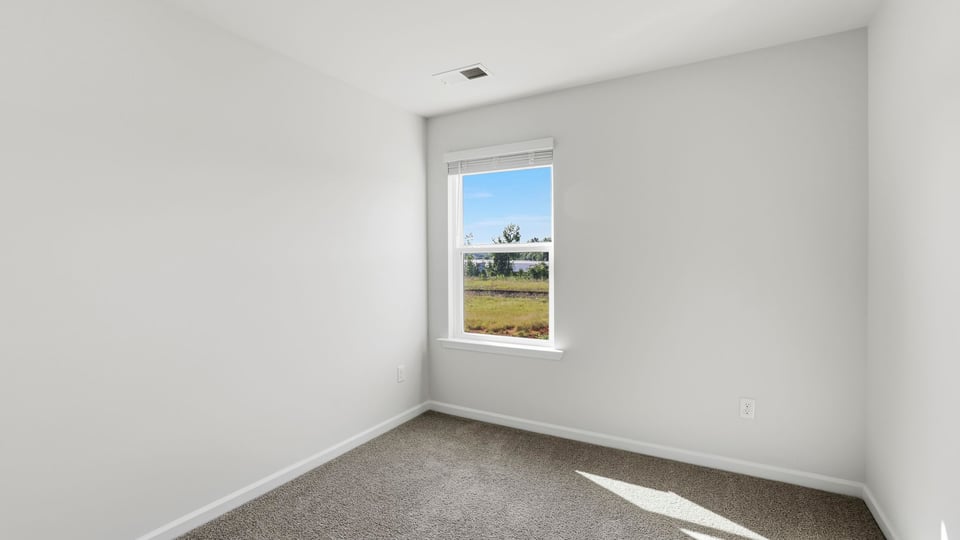 Bedroom with carpet and window.