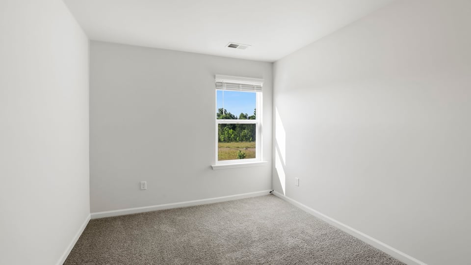 Bedroom with carpet and window.