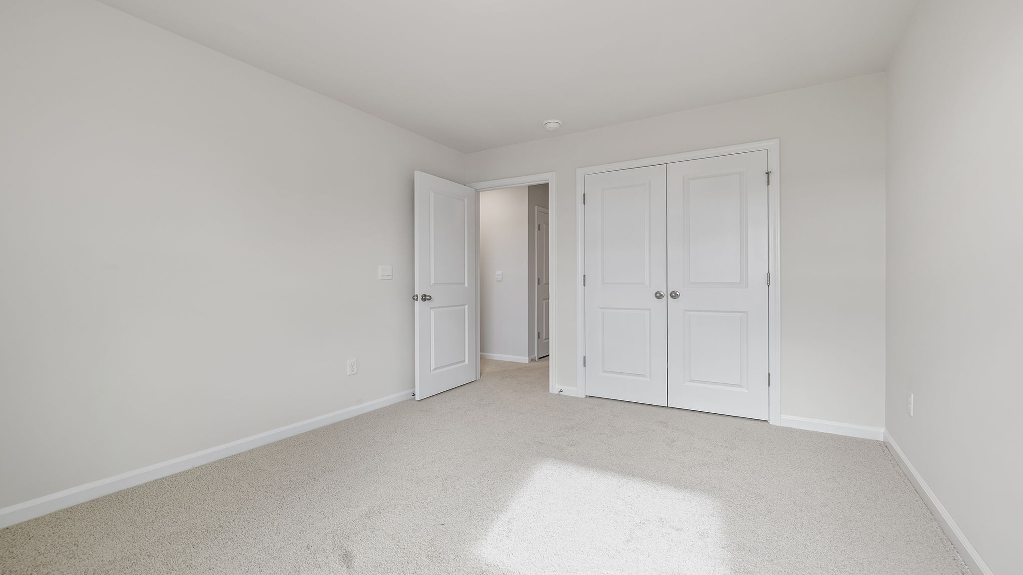Bedroom with carpet and windows.