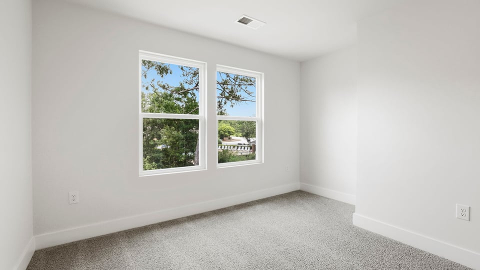 Bedroom with carpet and windows.