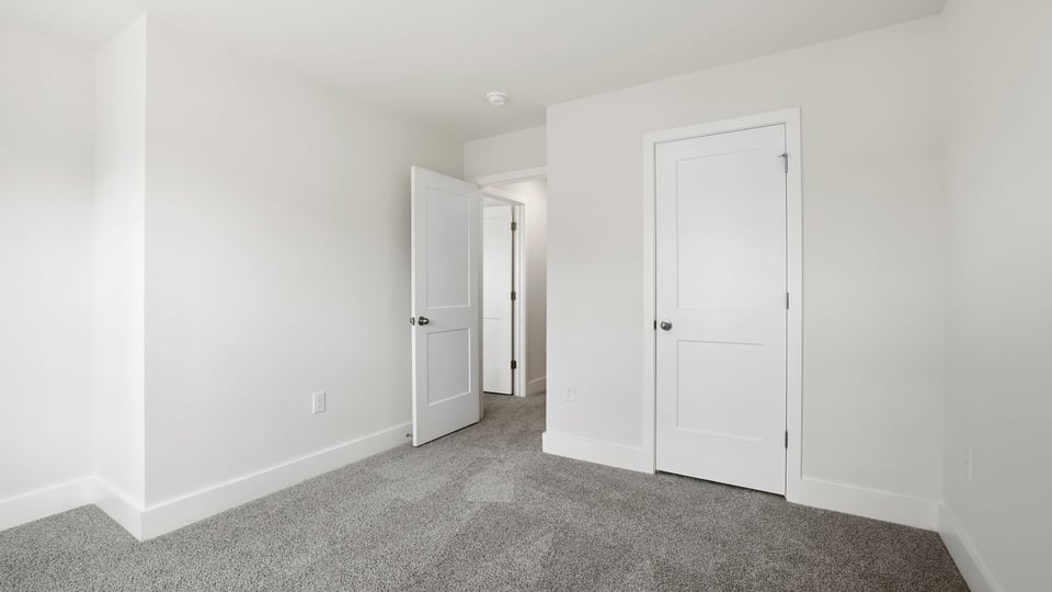 Bedroom with carpet and windows.