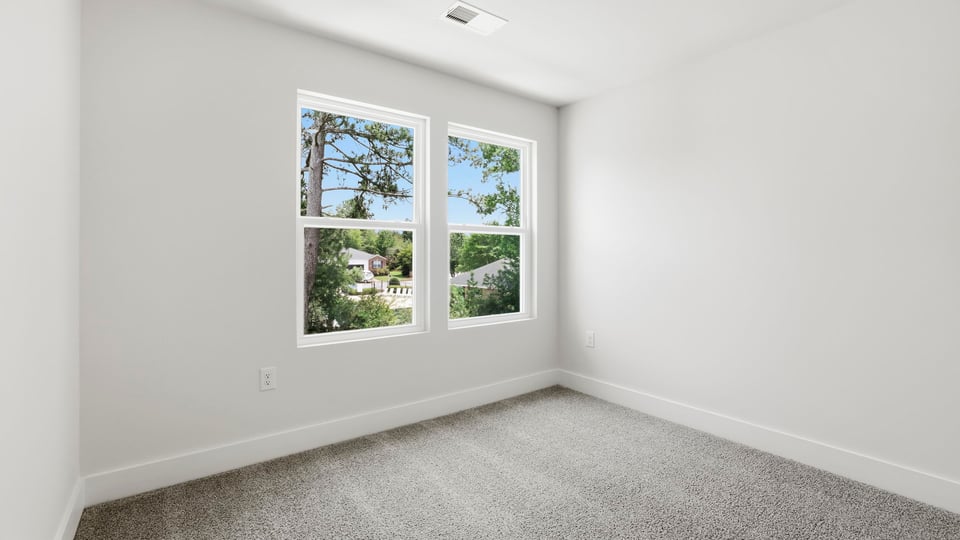 Bedroom with carpet and windows.