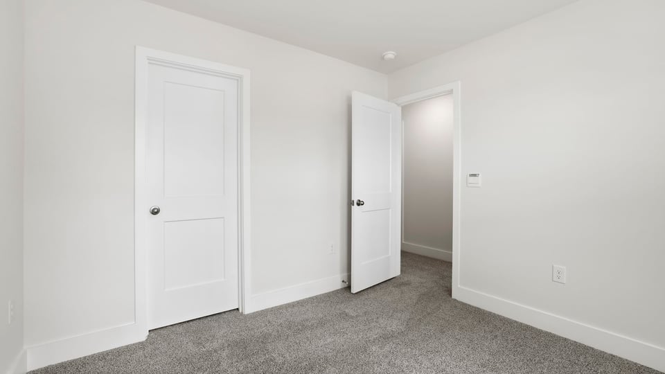Bedroom with carpet and windows.