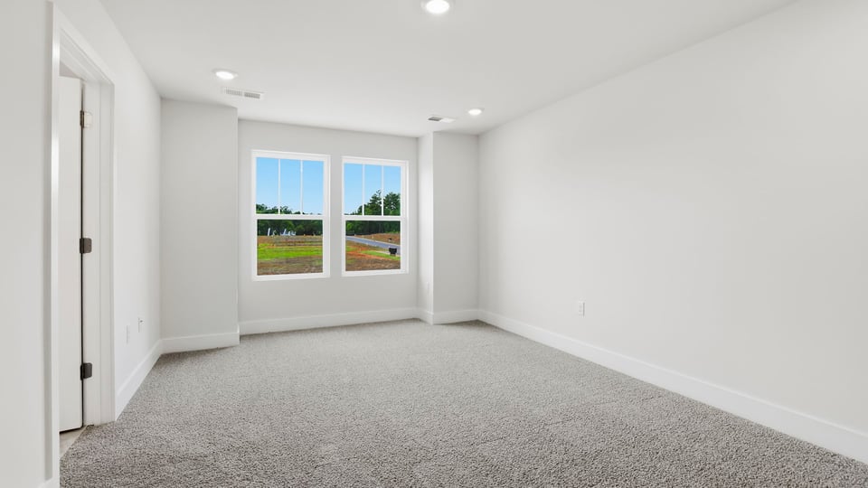 Bedroom with carpet and windows.
