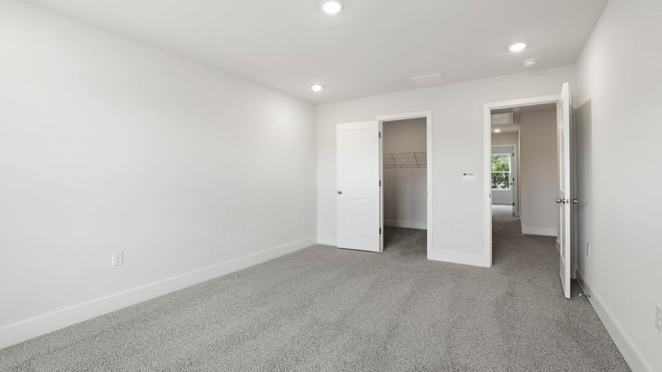 Bedroom with carpet and windows.
