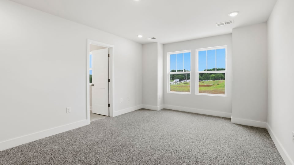 Bedroom with carpet and windows.
