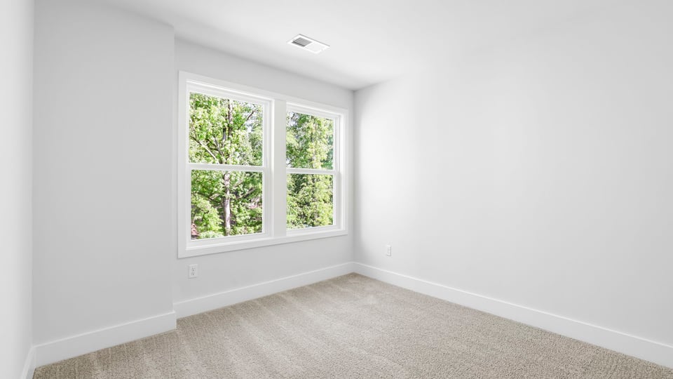 Bedroom with carpet and windows.