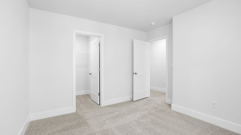 Bedroom with carpet and windows.