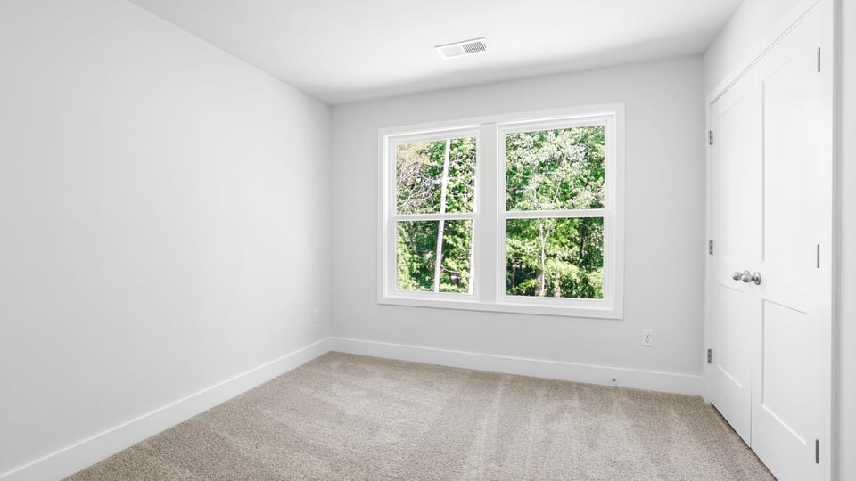 Bedroom with carpet and windows.