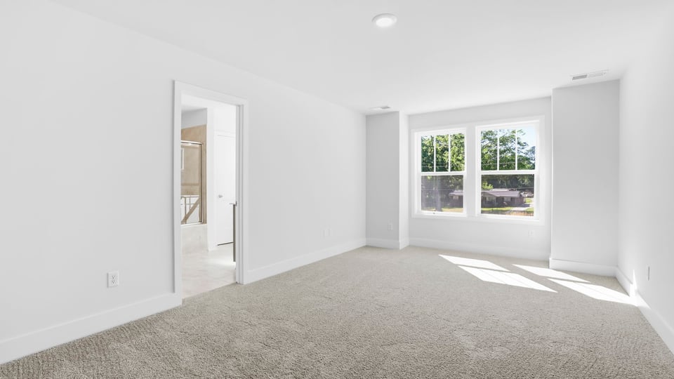 Bedroom with carpet and windows.
