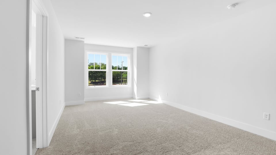 Bedroom with carpet and windows.