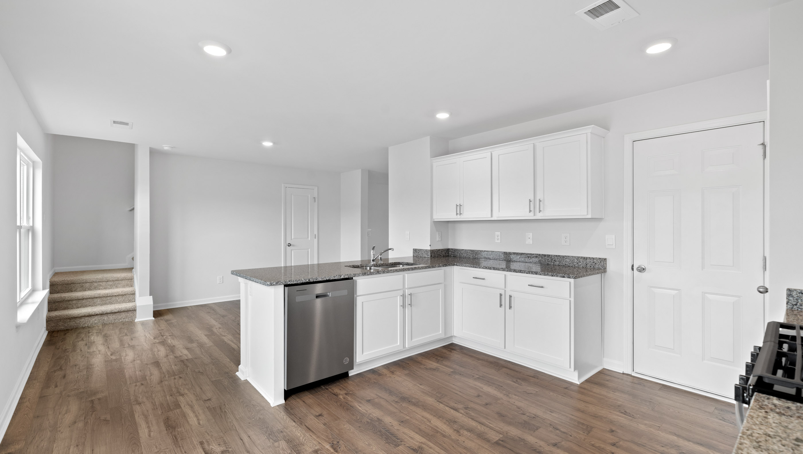 View of kitchen with granite counter tops.
