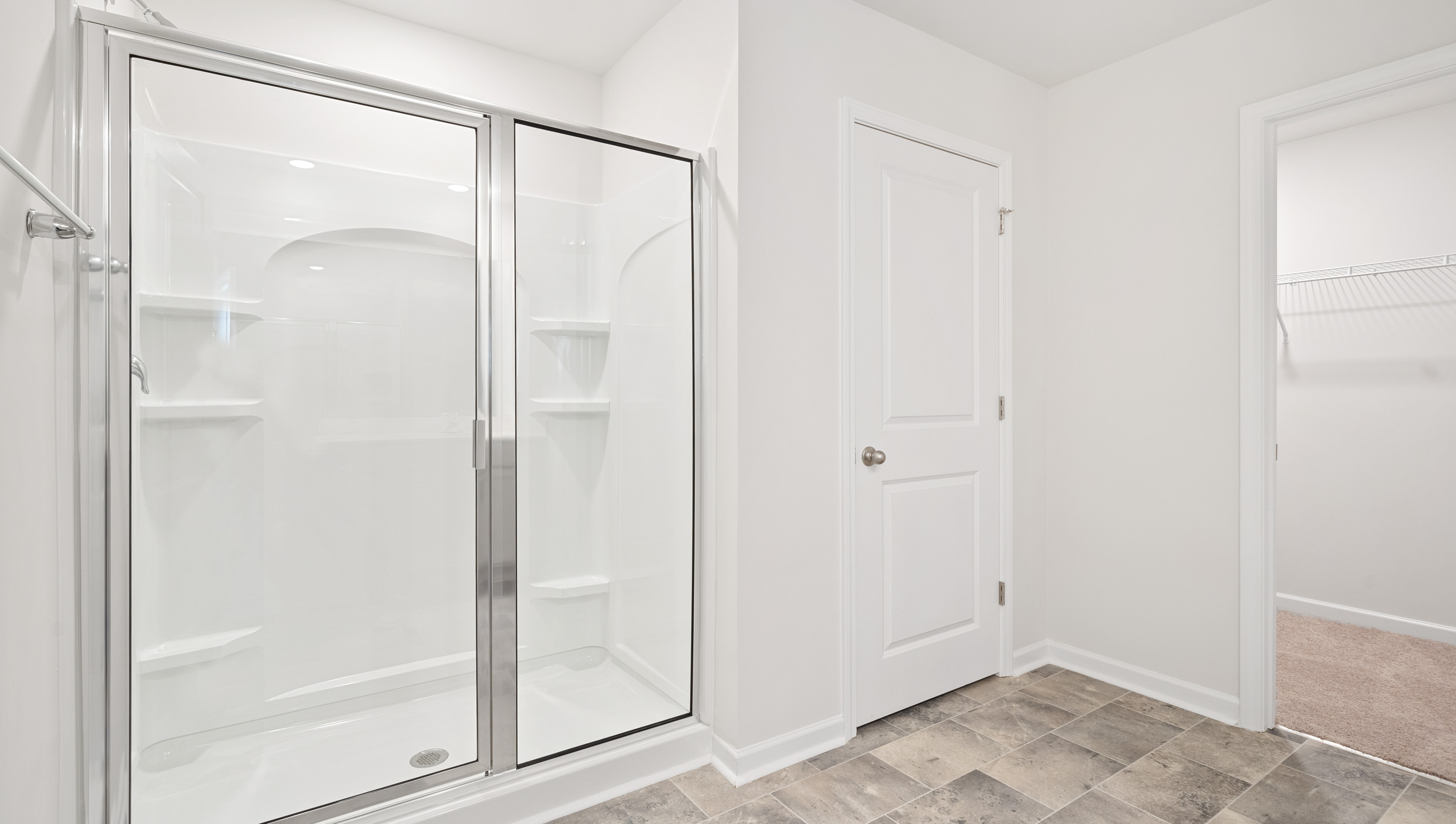 Bathroom with walk in shower and closet.