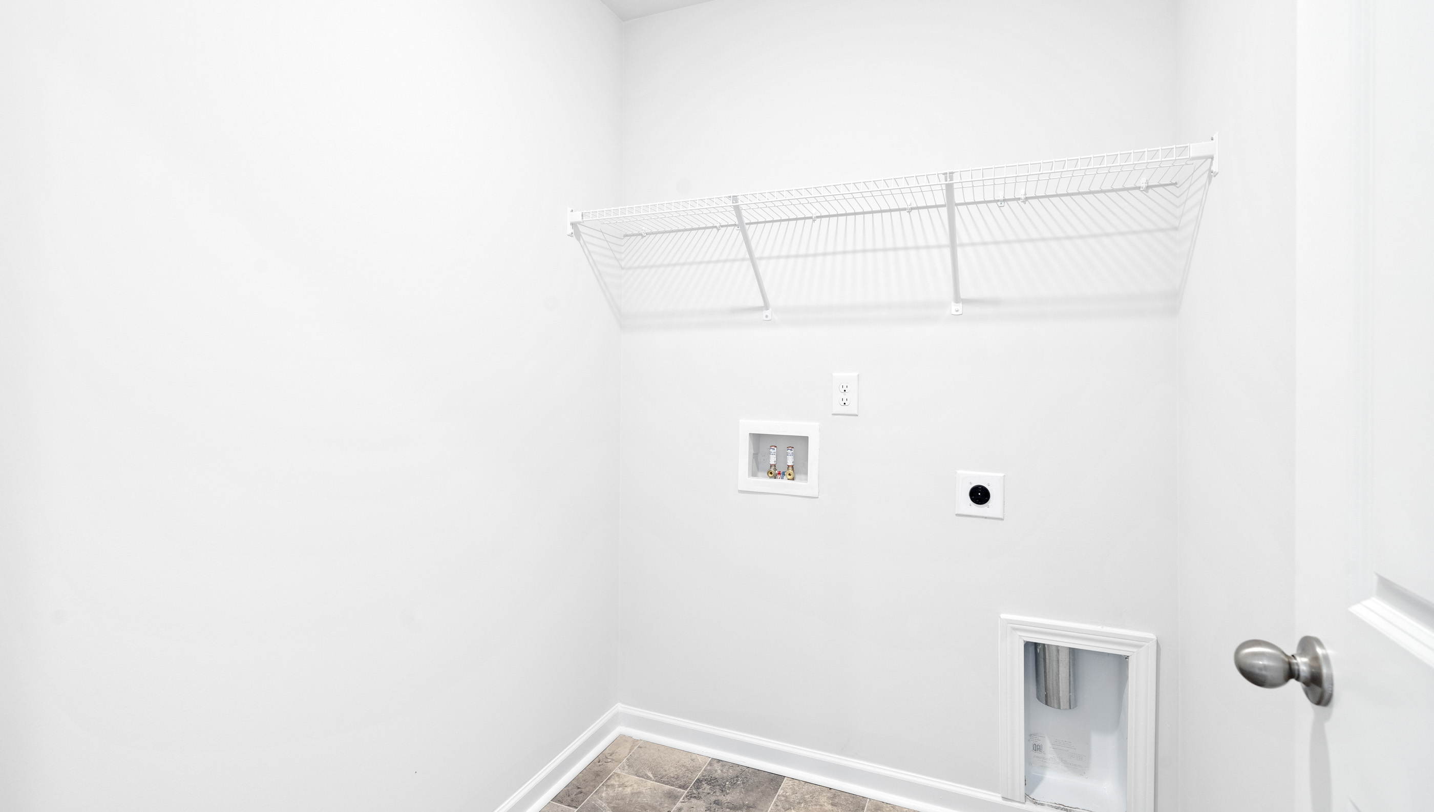 Laundry room with hanging storage racks.