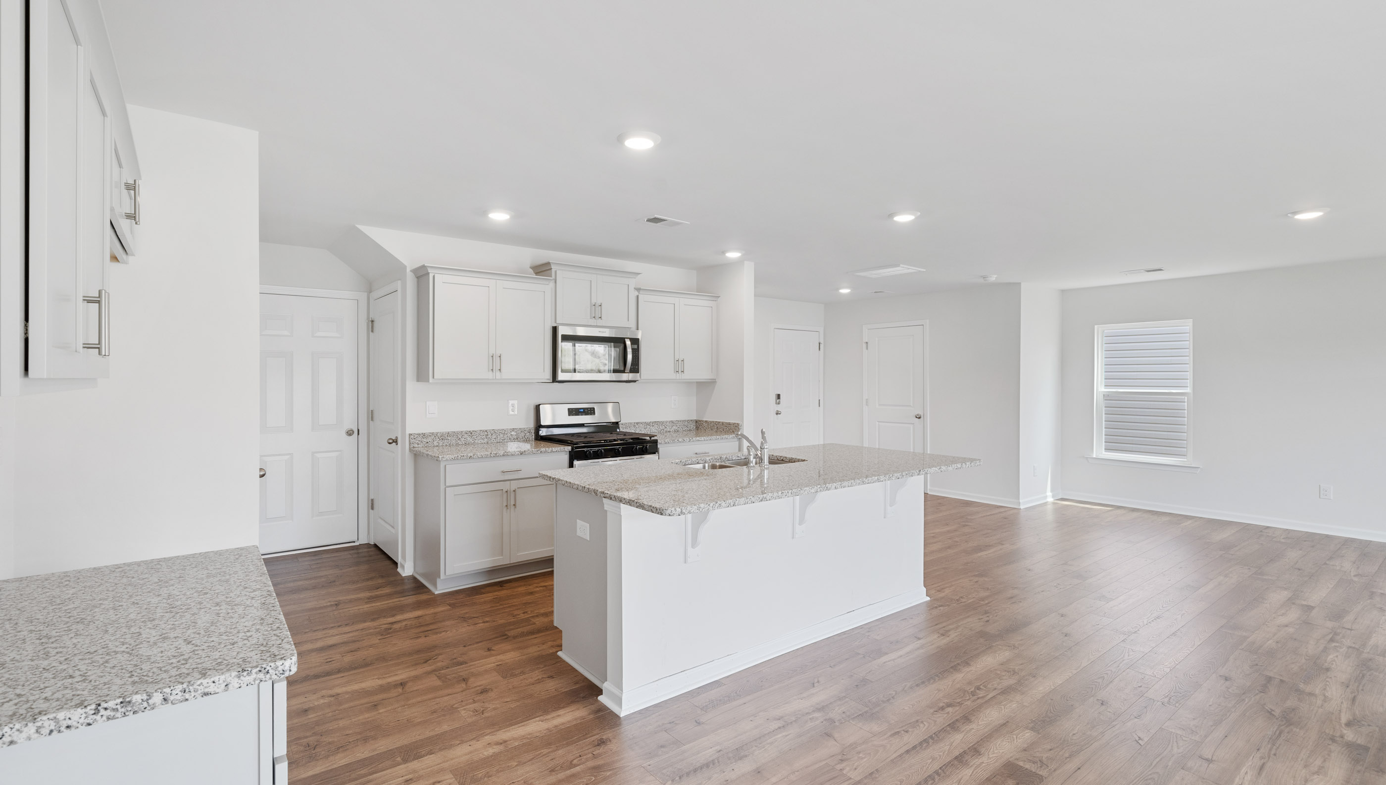 Kitchen and island with white cabinets.