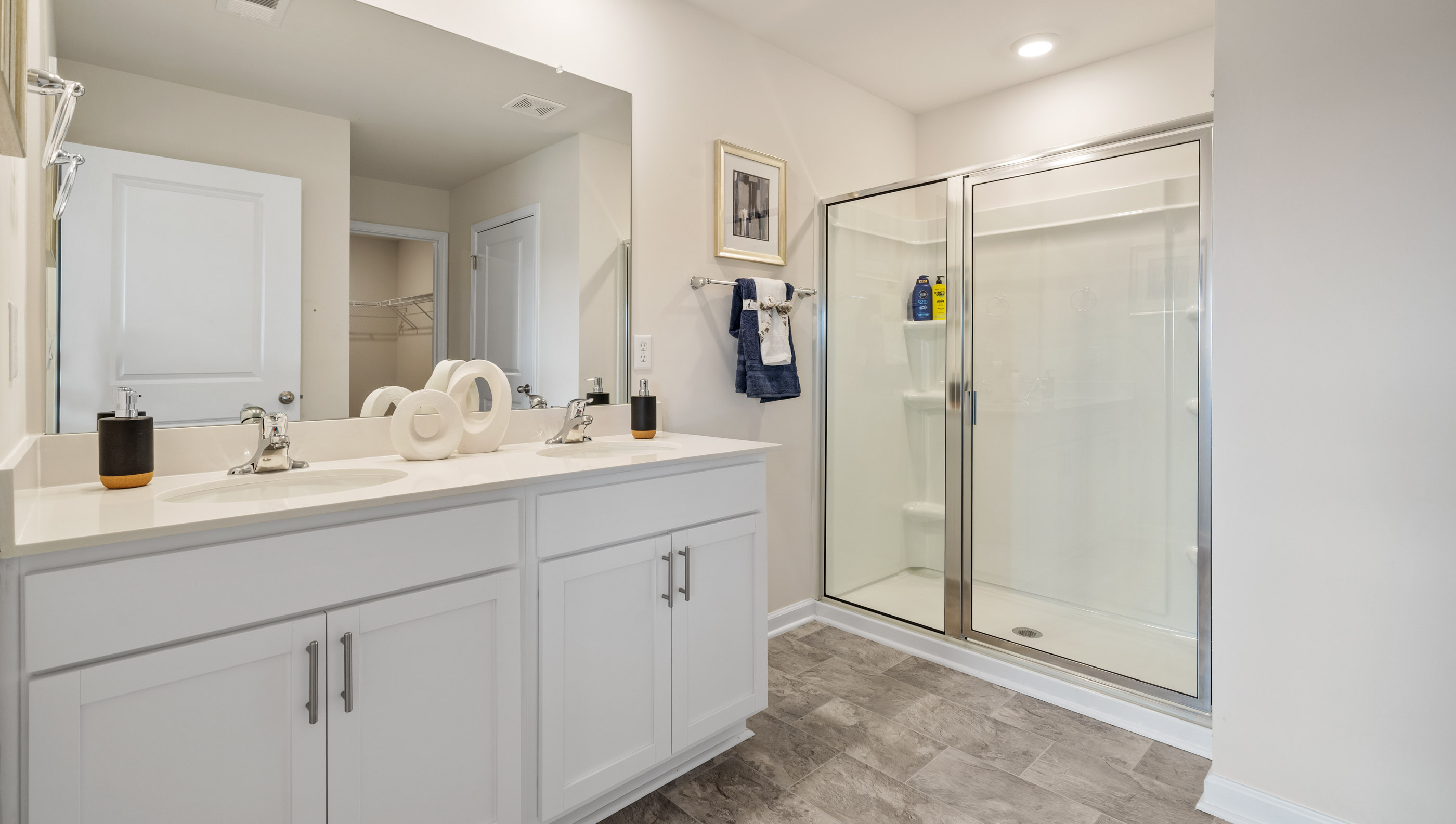 Bathroom with double vanity sink and walk in shower.