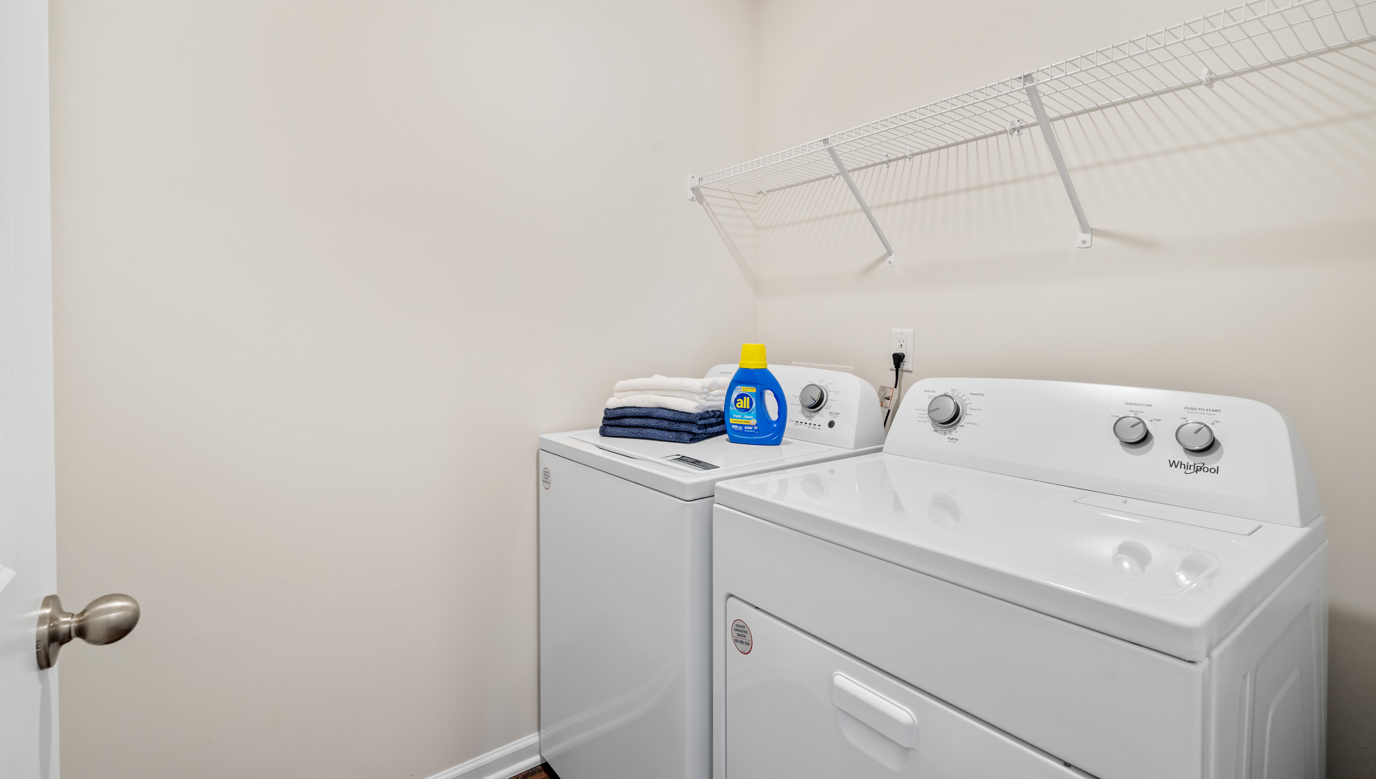 Laundry room with hanging storage shelves.