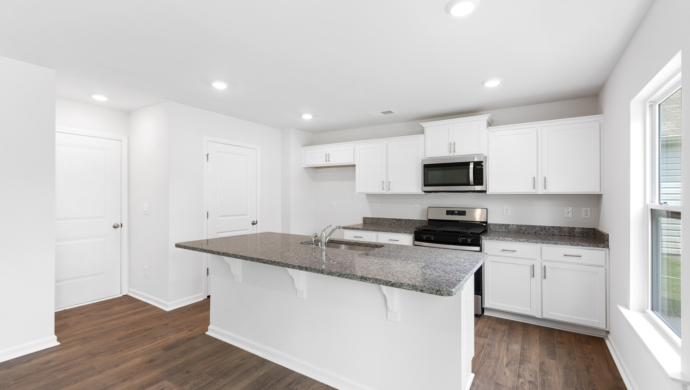 Kitchen and island with white cabinets.