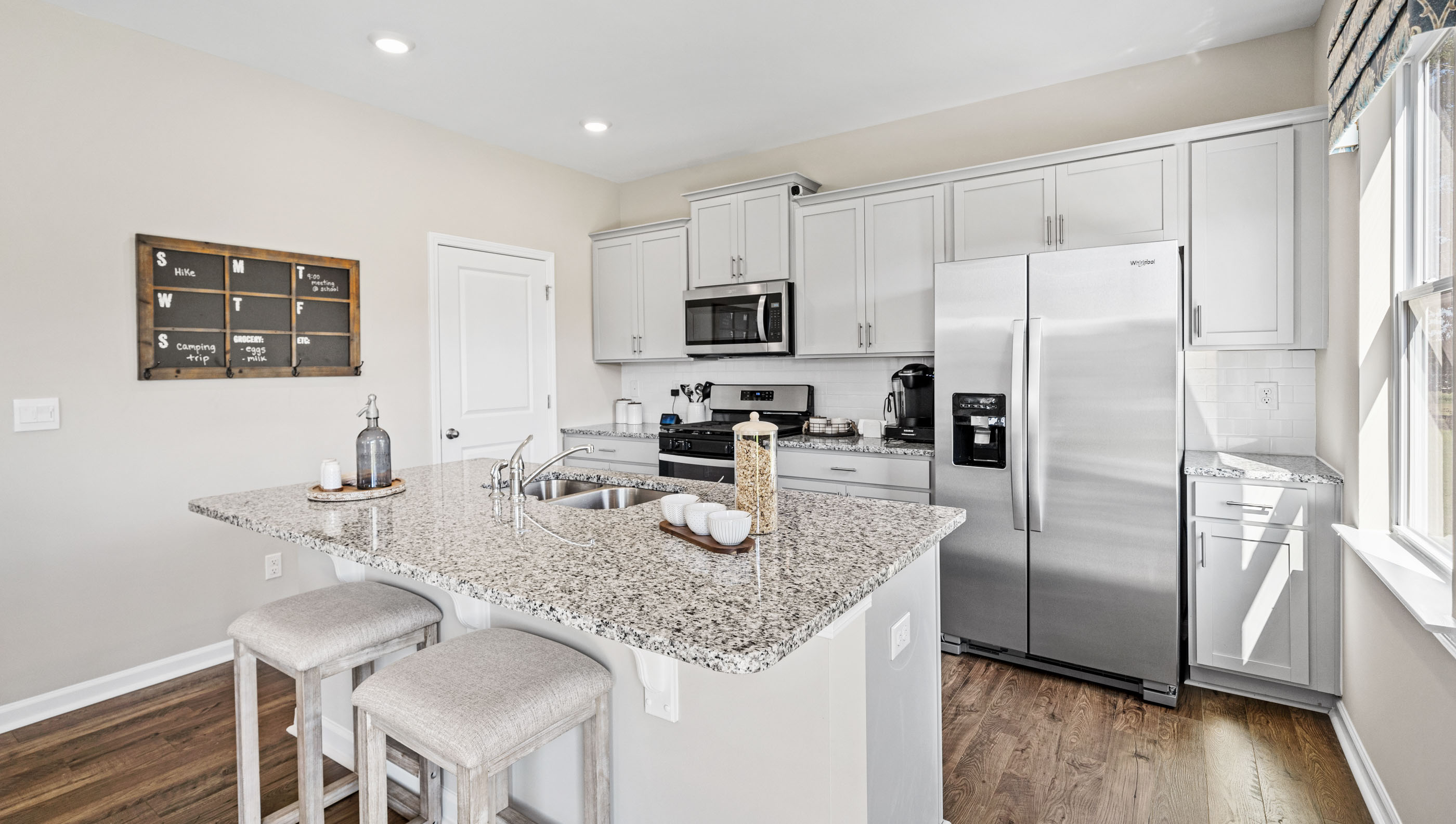 Kitchen and island with white cabinets.