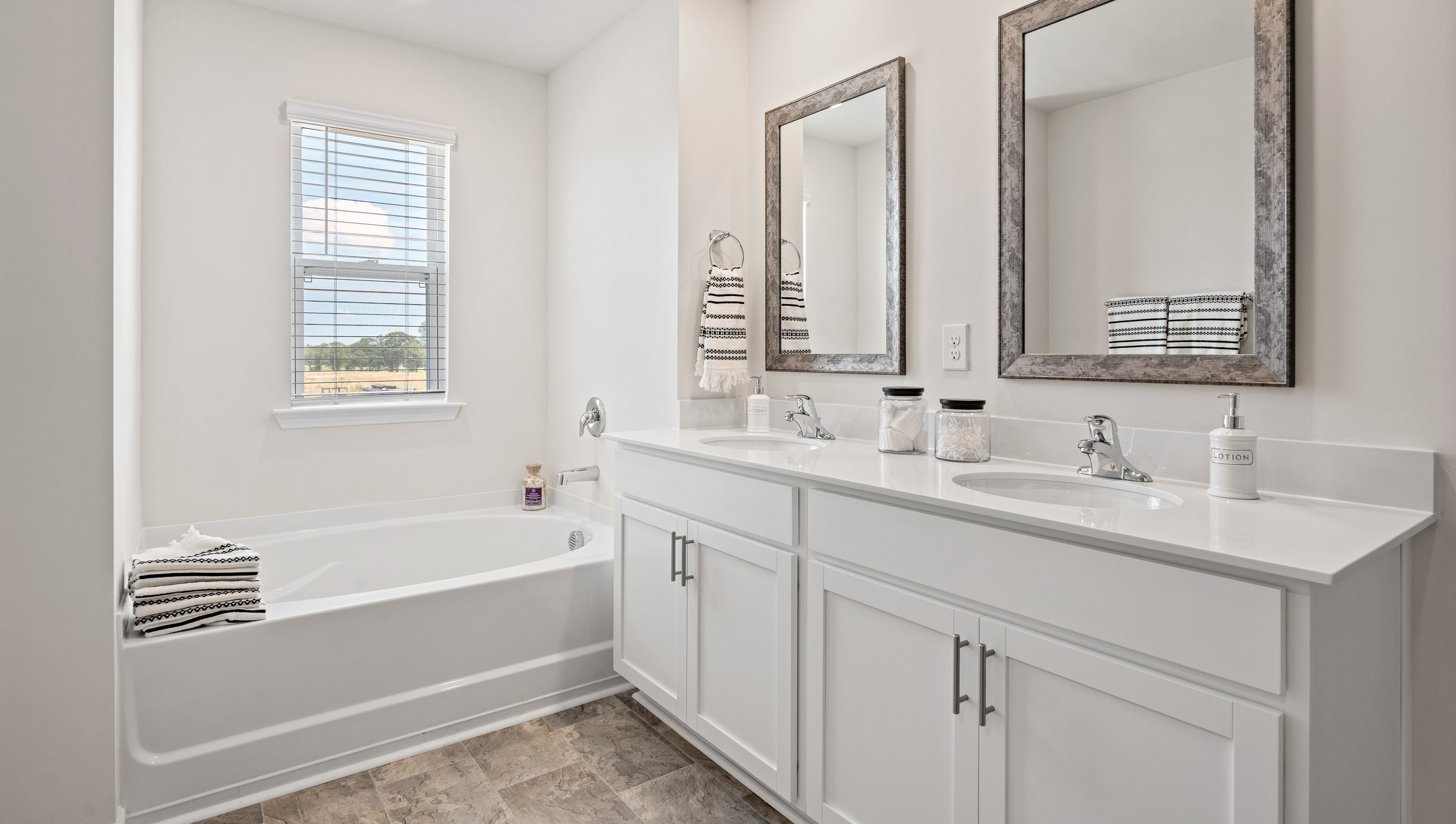 Bathroom with double vanity sink and tub.