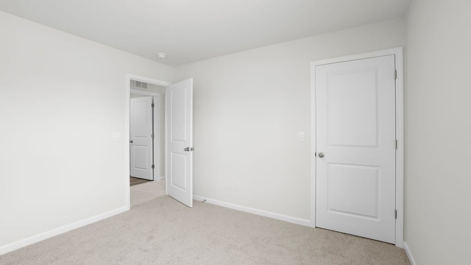 Bedroom with carpet and windows.