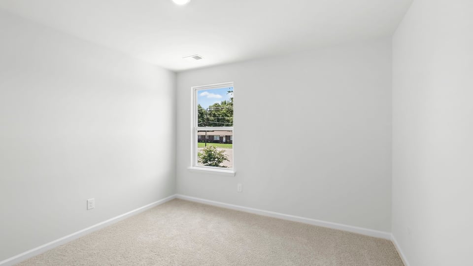 Bedroom with carpet and windows.