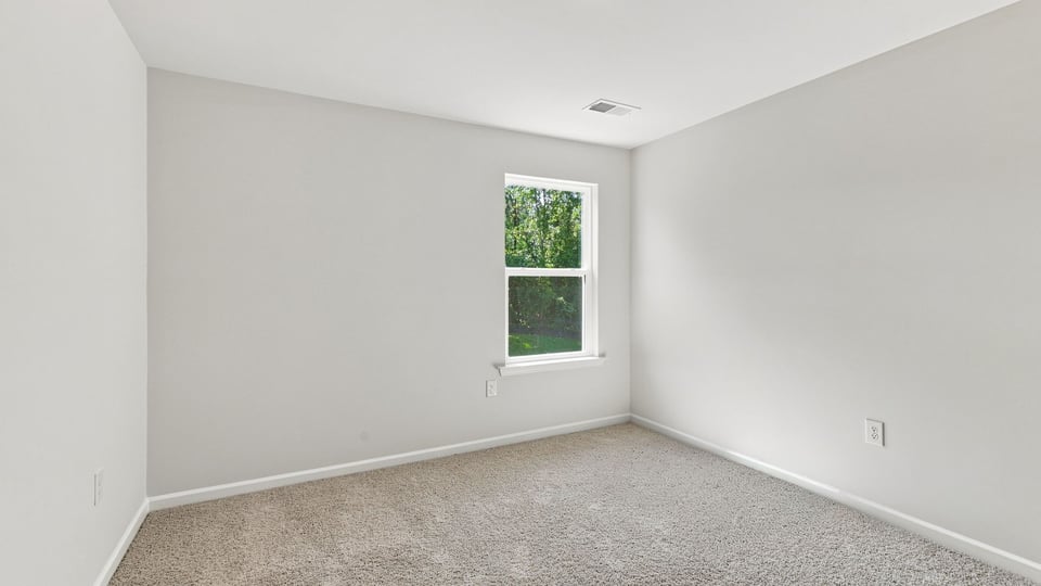 Bedroom with window and carpet.