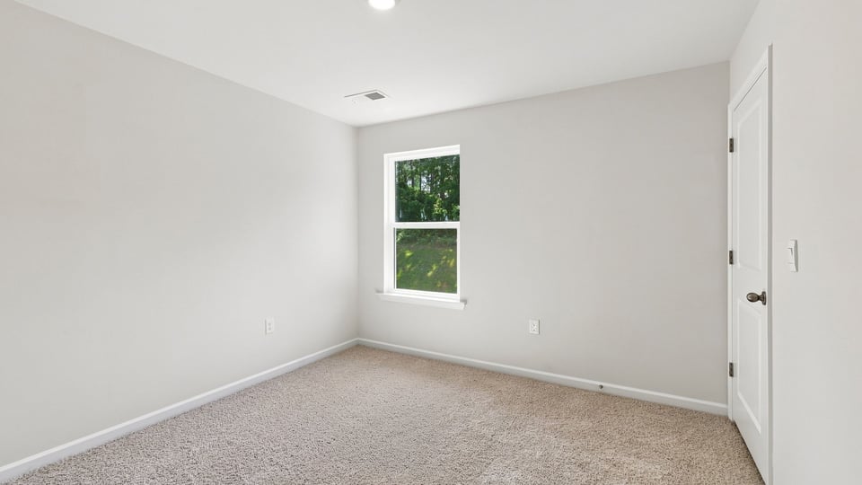 Bedroom with window and carpet.